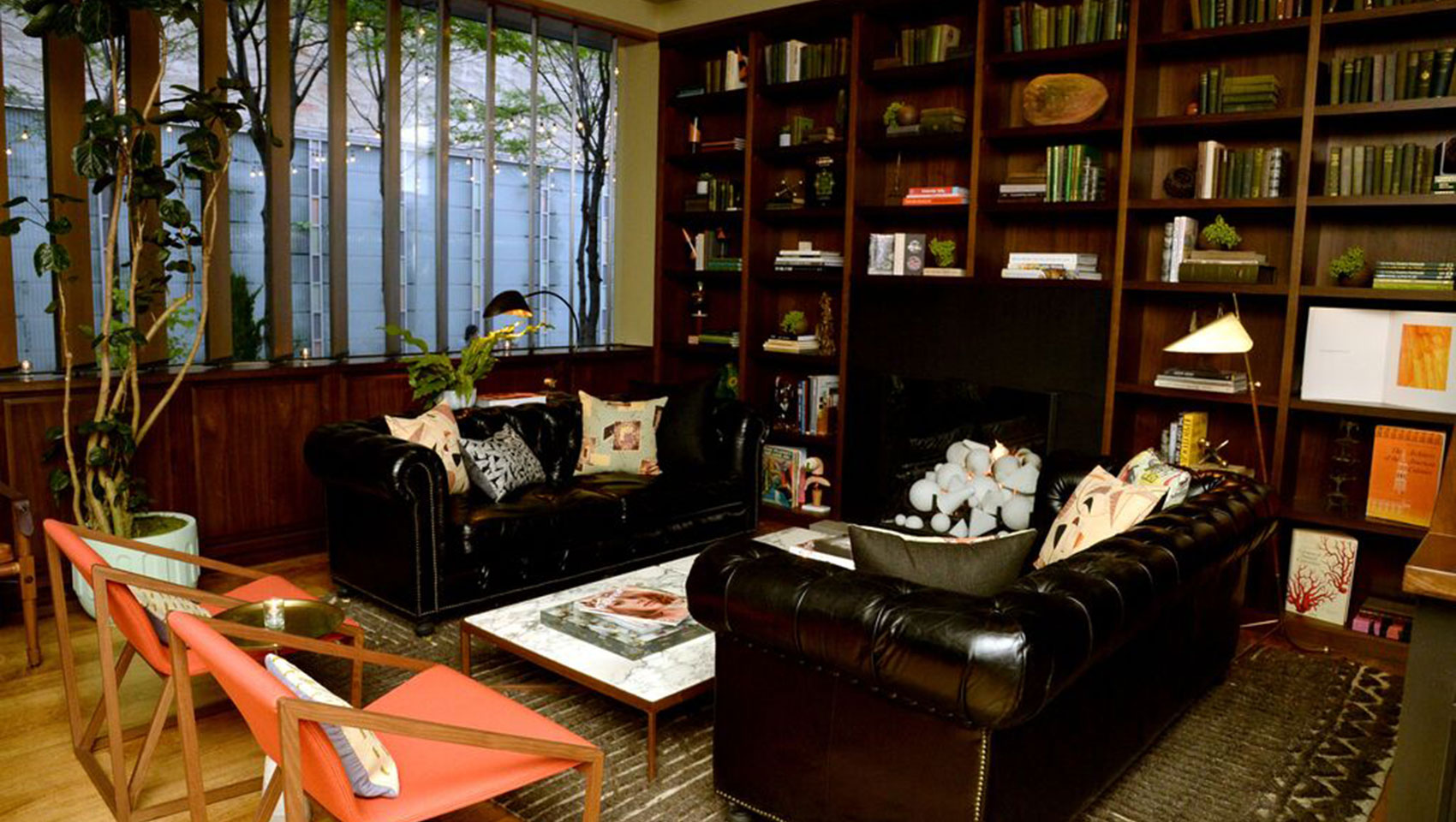 Back Bar lounge seating with leather couches, marble coffee table, and shelves with books and accent pieces