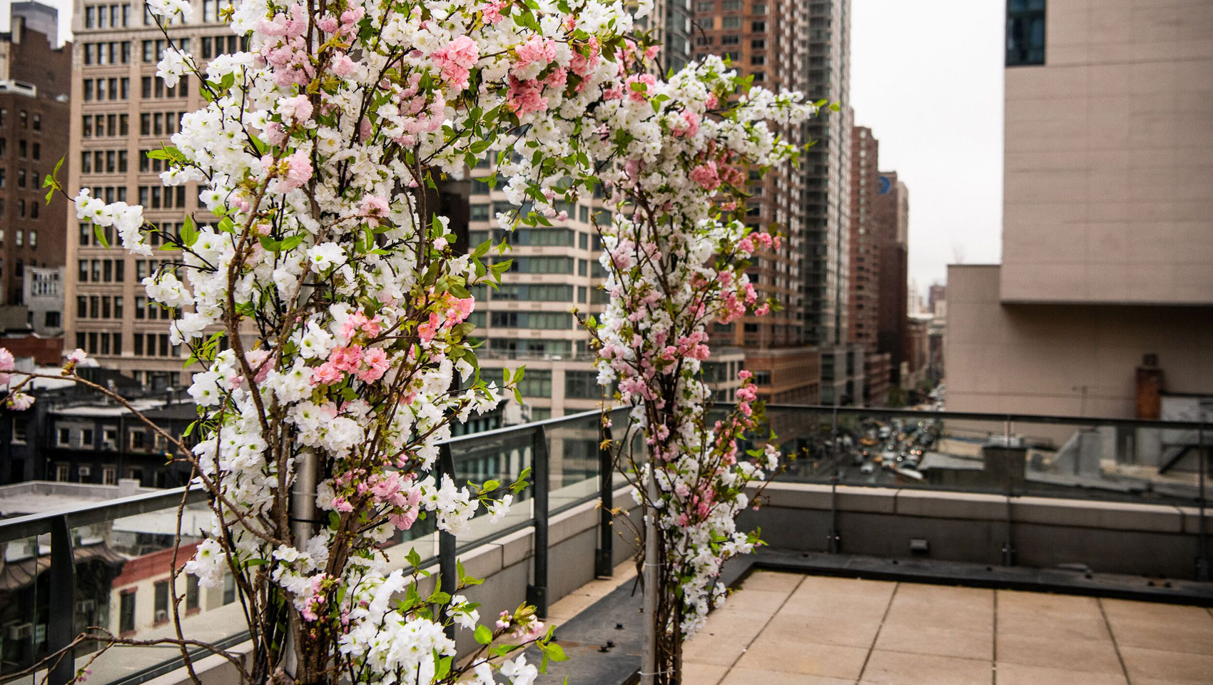 Floral wedding arch on top of balcony overlooking city views