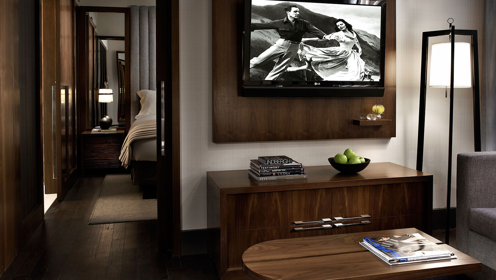 Kimpton Hotel Eventi Executive King Suite showing living area with TV and open doorway peering into bedroom